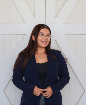 Angelica Barrera smiling in black clothing and wearing glasses