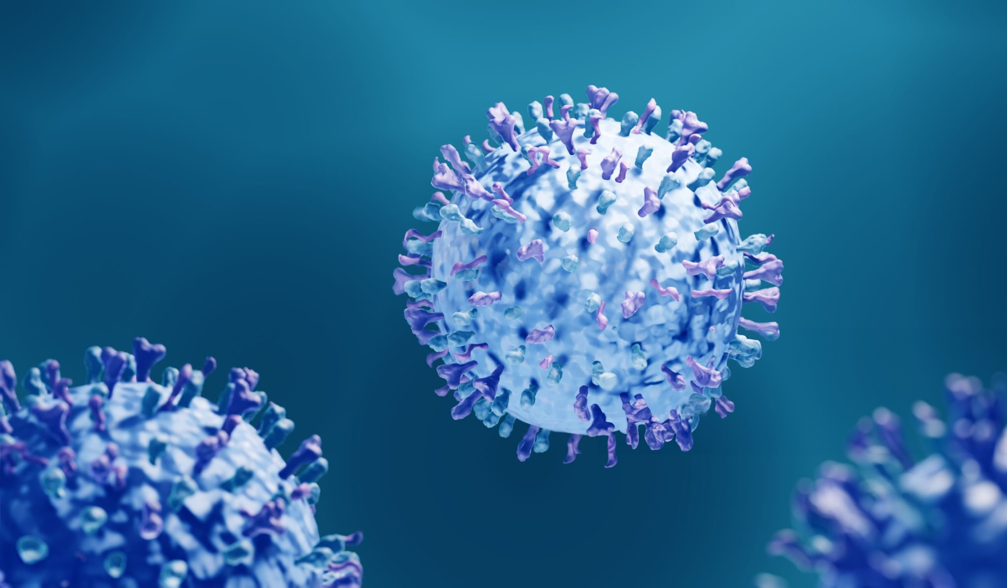 The image shows a close-up, 3D rendering of the Respiratory Syncytial Virus (RSV) particles against a deep teal background. The virus particles are depicted with a central, spherical shape covered in protruding spikes. The spikes, rendered in shades of purple and pink, represent the glycoprotein structures on the surface of the virus, which are key to its ability to infect host cells. The virus is highly detailed, with a sense of depth and realism to the imagery, highlighting the structure that is typically not visible to the naked eye. The overall mood of the image is clinical and informative.