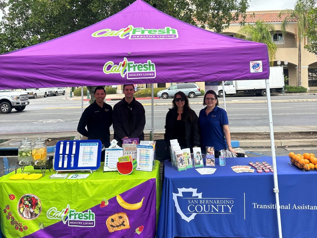 Nutrition and Wellness Services and Transitional Assistance Department staff at a farmers market.
