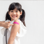Child pointing at bandage on arm