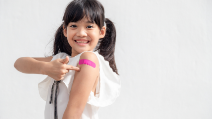 Child pointing at bandage on arm