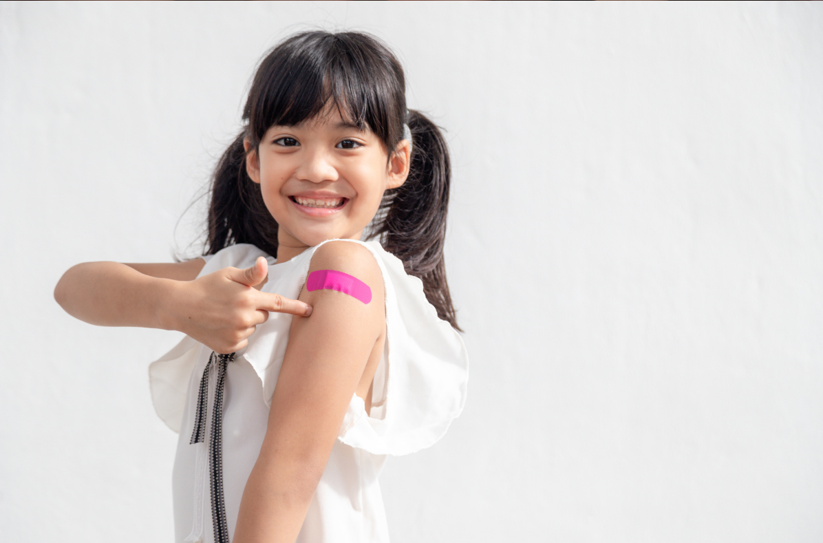 Child pointing at bandage on arm