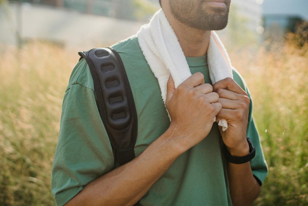 A man outside in the heat with a cooling towel around his neck.