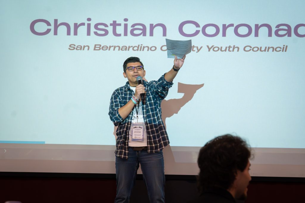 FNL leader holds up a paper while holding a mic. 