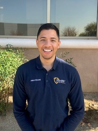 Kyle Greene posing in his San Bernardino County polo shirt 