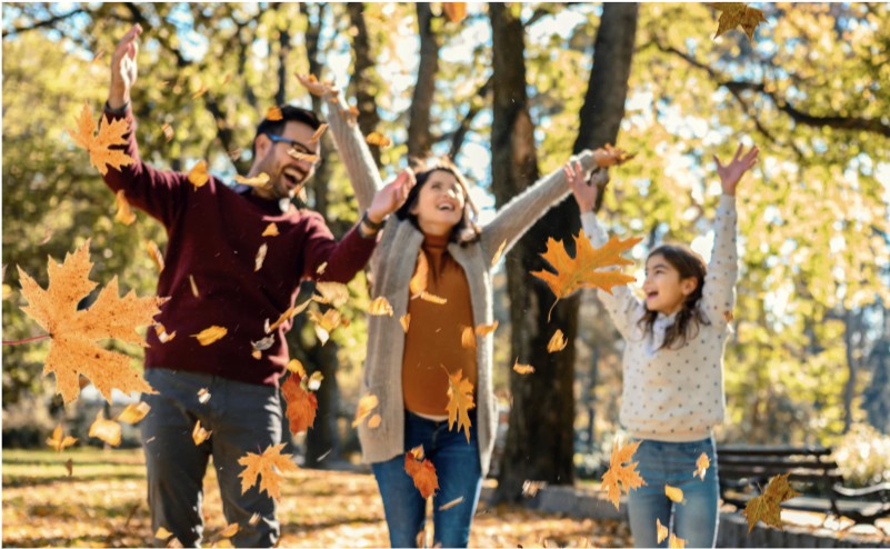 A group of people are throwing leaves in the air.