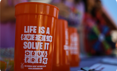 A red cup says "Life is a Puzzle, Solve it drug free"