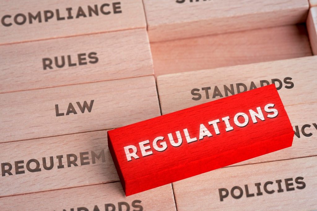Block pieces placed side by side. One block stands out from the rest and reads "Regulations" on a red block.