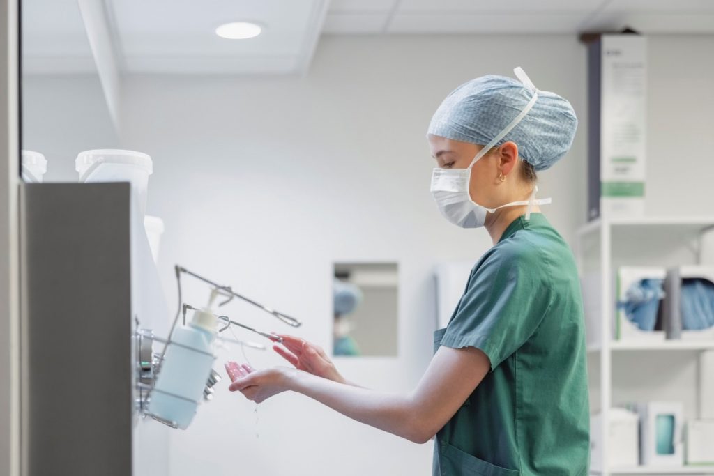 A young nurse washes her hands.