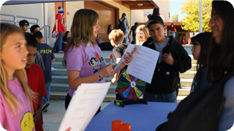 Young students are tabling at event.