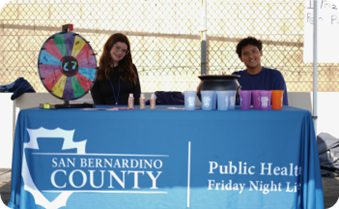 Two young students table at an event.
