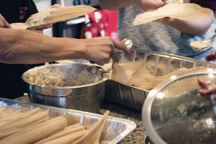A family preparing tamales on the kitchen