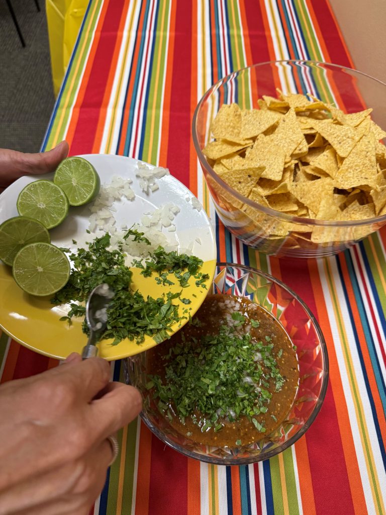 Leticia Allen adding in onions and cilantro to her salsa