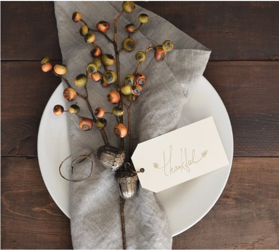 A place setting on a table with a napkin and flowers