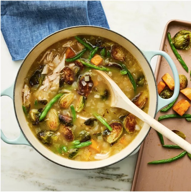 A pot of soup with vegetables and green beans